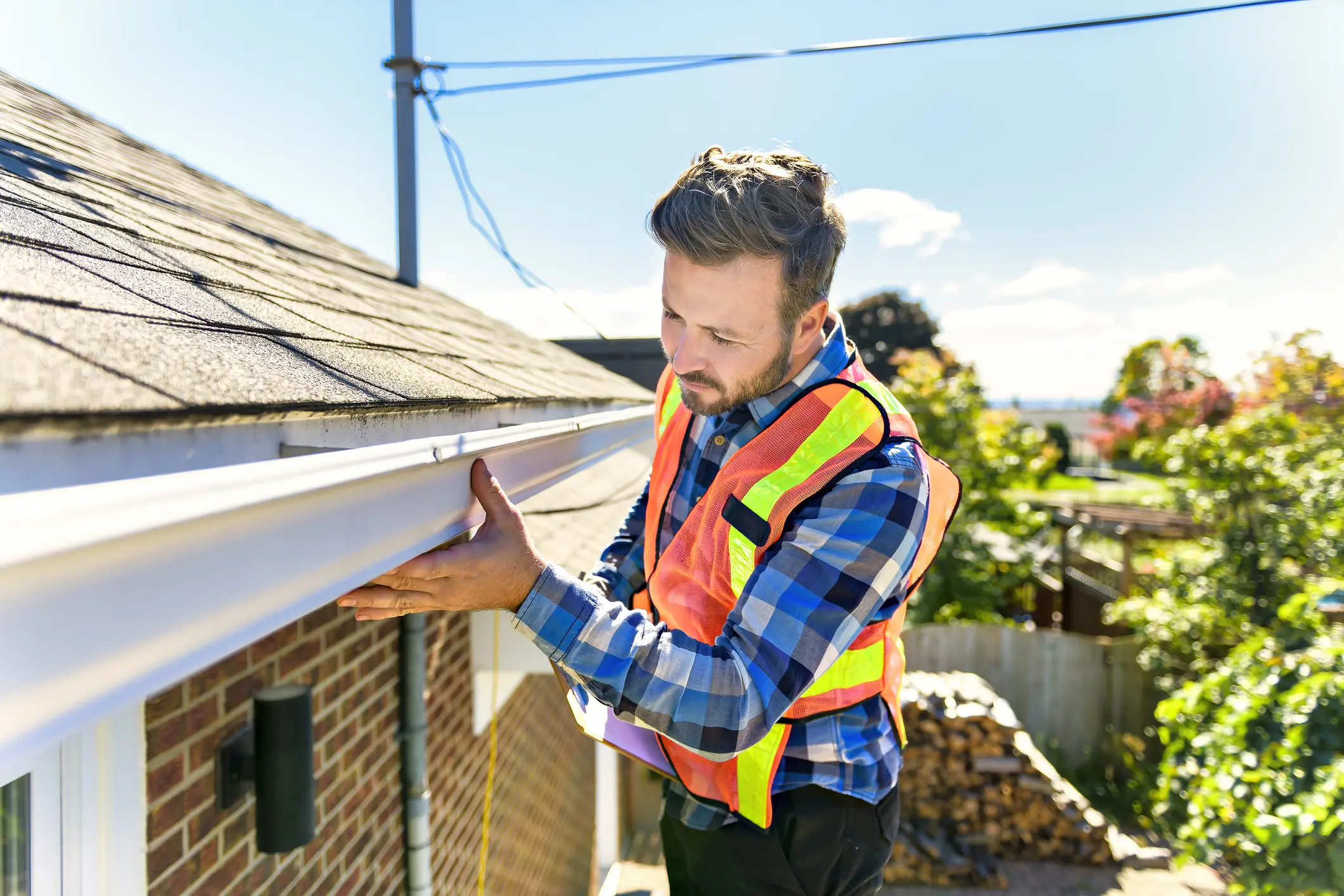 Man in safety vest checking gutters