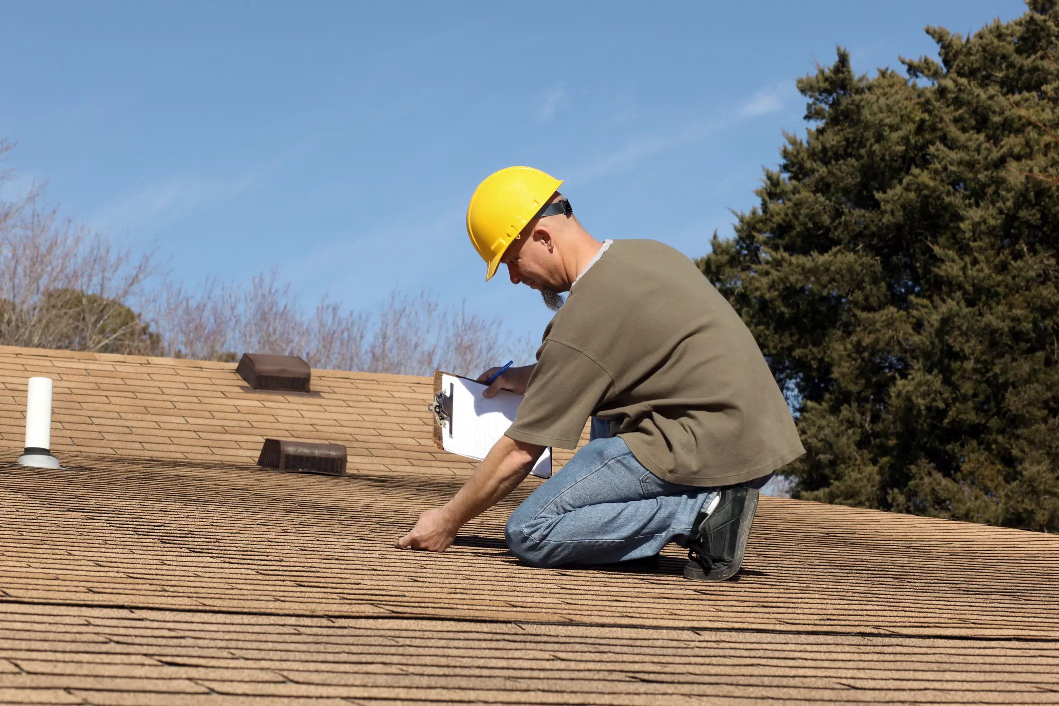 Man inspecting roof with safety helmet