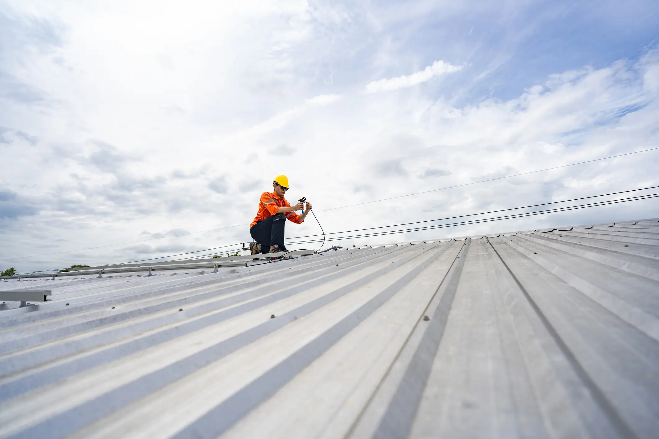 Construction worker inspecting a metal roof