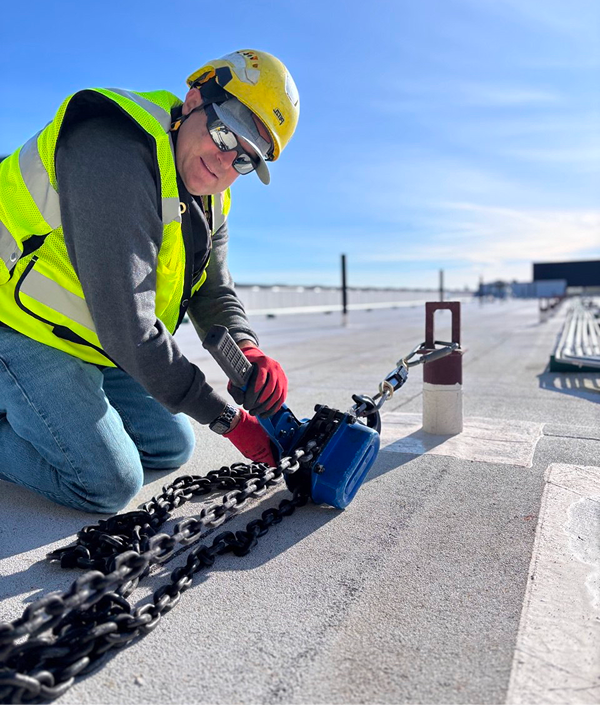 Construction worker securing rooftop chains