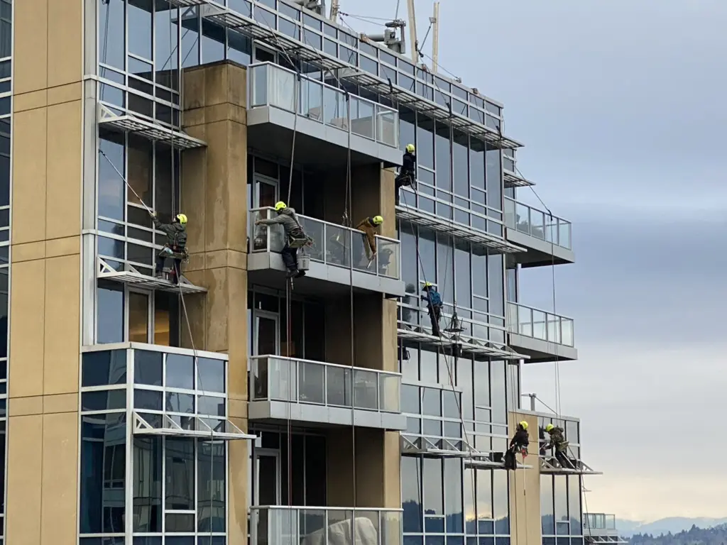  Construction worker working on a modern glass building.